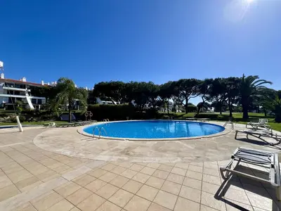a swimming pool with two chairs next to it at Vilamoura Sunny Garden With Pool by Homing in Vilamoura