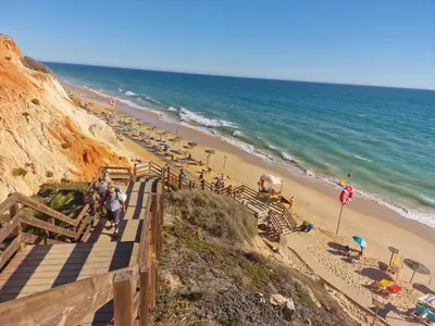 a beach with a bunch of umbrellas and the ocean at Apartamento Torre da Medronheira in Olhos de Água