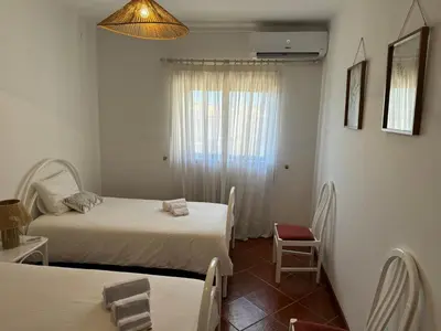 a small room with two beds and a window at Apartamento Torre da Medronheira in Olhos de Água