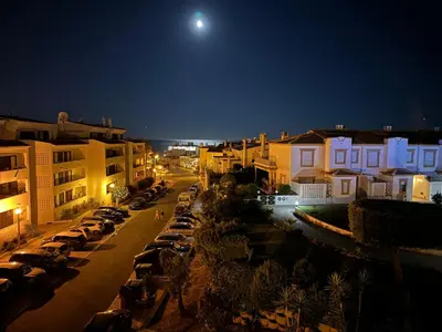 a city street at night with cars parked at Apartamento Torre da Medronheira in Olhos de Água