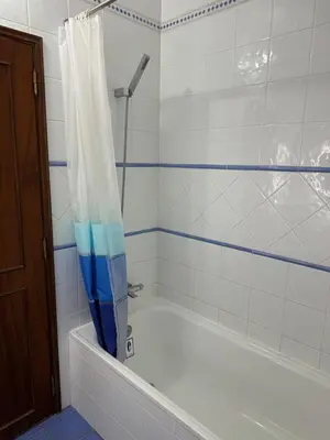a bathroom with a tub with a shower curtain at Apartamento Torre da Medronheira in Olhos de Água