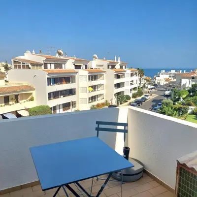 a blue table on a balcony with buildings at Apartamento Torre da Medronheira in Olhos de Água