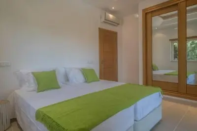 a bedroom with a large white bed with green sheets at Crest 5 - 8 Pax Golf & Beach Swimming pool in Almancil