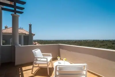 a patio with two chairs and a table on a balcony at Crest 5 - 8 Pax Golf & Beach Swimming pool in Almancil