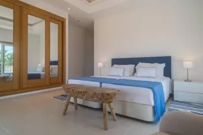 a bedroom with a bed and a bench in it at Crest 5 - 8 Pax Golf & Beach Swimming pool in Almancil