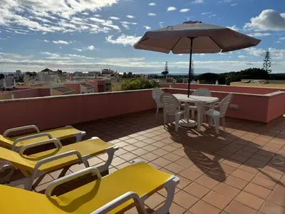 a patio with a table and chairs and an umbrella at Old Village Prestige - Vilamoura in Vilamoura