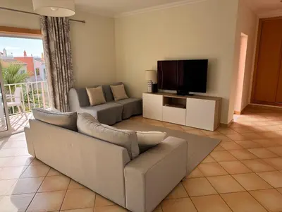 a living room with a couch and a flat screen tv at Old Village Prestige - Vilamoura in Vilamoura