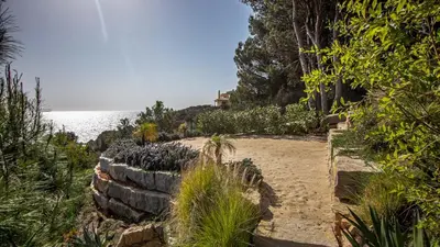 a stone path leading to the beach with a house in the background at Algarve Villa for Contemporary Design & Sea Views in Albufeira