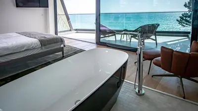 a bedroom with a tub and a balcony with a view of the ocean at Algarve Villa for Contemporary Design & Sea Views in Albufeira