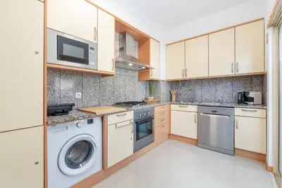 a white dining room with a white table and chairs at BnB Homes White Rose Garden Apartment with 2 Terraces & 2 Swimming Pools in Albufeira