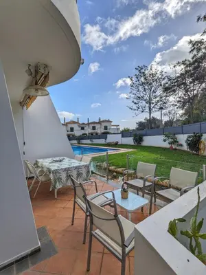 a patio with chairs and a table and a pool at Villa Quintaloes, 5 mins from Old Town Albufeira in Albufeira