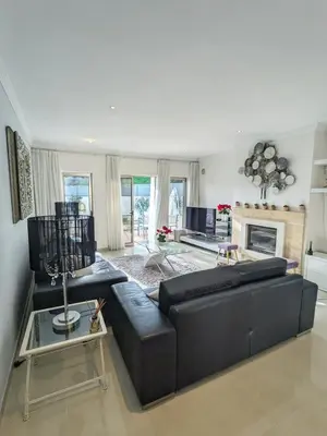 a living room with a black couch and a fireplace at Villa Quintaloes, 5 mins from Old Town Albufeira in Albufeira