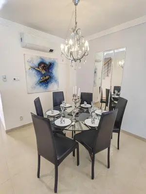 a dining room with a table and chairs and a chandelier at Villa Quintaloes, 5 mins from Old Town Albufeira in Albufeira