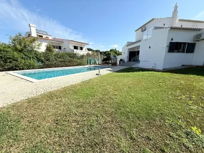 a porch with couches and a wooden pergola at Villa Oasis 4-Bedroom Retreat with Pool in Vilamoura in Quarteira
