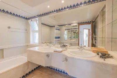a bathroom with two sinks and a tub and a mirror at Ocean Vista Retreat with Beach & Pool Access by Drago Rentals in Albufeira