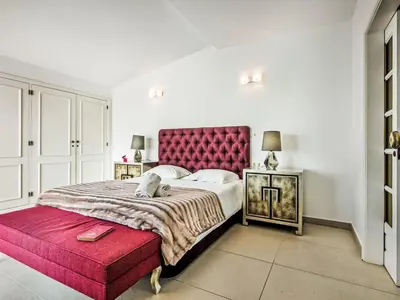 a bedroom with a large bed with a red headboard at Holiday Home Praia V5 VIP Properties by Interhome in Vilamoura