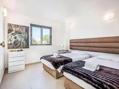 two beds in a room with white walls at Holiday Home Praia V5 VIP Properties by Interhome in Vilamoura