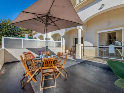 a patio with a table and chairs and an umbrella at Holiday Home Encosta dos Salgados by Interhome in Galé