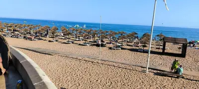 a beach with a bunch of chairs and umbrellas at Pateo Apartment - One Bedroom in Albufeira in Albufeira