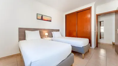 two beds in a hotel room with at Sunny Retreat with Pool and Balcony by LovelyStay in Albufeira