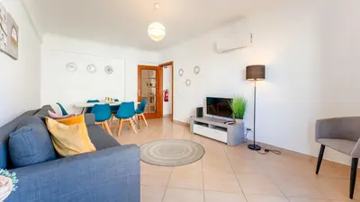a living room with a blue couch and a table at Sunny Retreat with Pool and Balcony by LovelyStay in Albufeira
