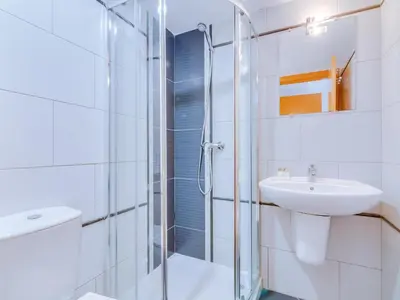 a white bathroom with a sink and a shower at AL - Apartamento Canto do Mar frente à praia in Quarteira