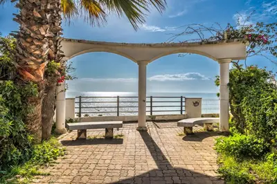 a pavilion with two benches in front of the ocean at Varandas do Mar, Olhos de Agua, 1 Bed Apt AT23 in Olhos de Água