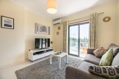 a living room with a couch and a tv at Vista Das Ondas 308 By RS in Olhos de Água