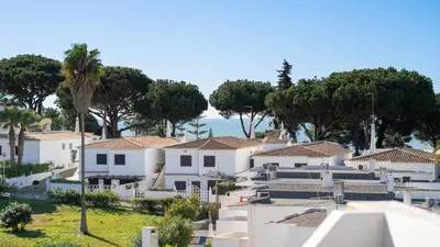 a row of white houses with trees in the background at Balaia Project by LovelyStay in Olhos de Água