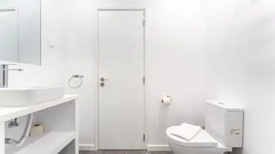 a white bathroom with a toilet and a shower at Balaia Project by LovelyStay in Olhos de Água
