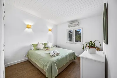 a bedroom with a bed with green sheets and a window at Villa Domus Vini by Villa Plus in Guia