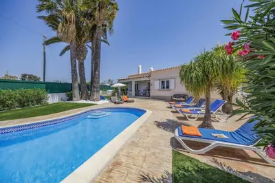 a swimming pool with lounge chairs next to a house at Villa Domus Vini by Villa Plus in Guia