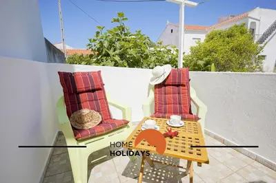 a table and chairs on a balcony with the words home holidays at #242 Old Town - Casa de Albufeira 2 by Home Holidays in Albufeira