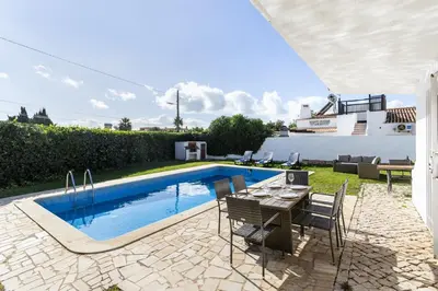 a patio with a table and chairs next to a swimming pool at TAC - Villa Oura in Albufeira