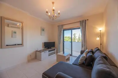 a living room with a couch and a television at Vista das Ondas 208 by JS in Olhos de Água