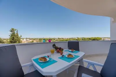 a white table with food and drinks on a balcony at Vista das Ondas 208 by JS in Olhos de Água