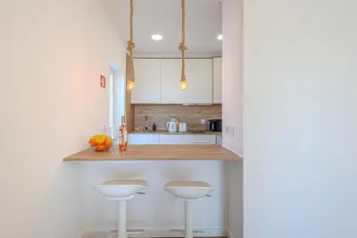 a kitchen with two white stools and a counter at Galé Beach Studio - Albufeira - Sea View in Guia