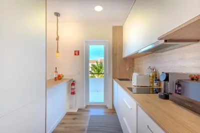 a kitchen with white cabinets and a view of the ocean at Galé Beach Studio - Albufeira - Sea View in Guia