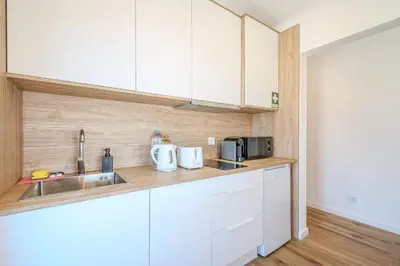 a kitchen with white cabinets and a sink at Galé Beach Studio - Albufeira - Sea View in Guia