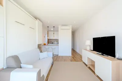 a living room with a white couch and a tv at Galé Beach Studio - Albufeira - Sea View in Guia