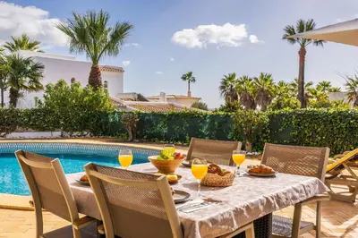 a table with food and drinks on it next to a pool at Villa Coral by OCvillas in Albufeira