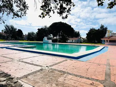 an empty swimming pool with blue water at Resort Albufeira Praia Oura in Albufeira