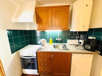 a small kitchen with wooden cabinets and a sink at Resort Albufeira Praia Oura in Albufeira