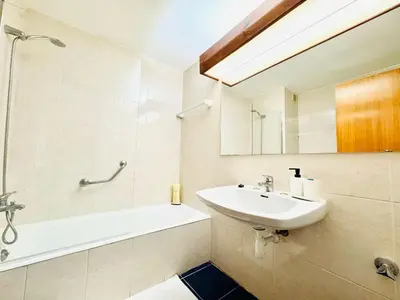 a bathroom with a sink and a tub and a mirror at Resort Albufeira Praia Oura in Albufeira