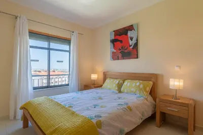 a bedroom with a bed and a large window at Vista das ondas 205 by AS in Olhos de Água