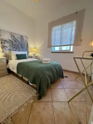 a bedroom with a large bed and a window at Cosy 3 bed Apartment Albufeira Old town in Albufeira