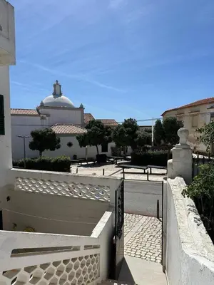 a white building with a gate in front of a street at Cosy 3 bed Apartment Albufeira Old town in Albufeira