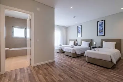 a hotel room with two beds and a bath tub at DK Stays Residences Albufeira in Albufeira
