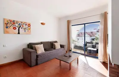 a living room with a couch and a table at Alta Oura in Albufeira