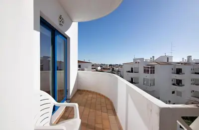 a balcony with a bench and a view of buildings at Alta Oura in Albufeira